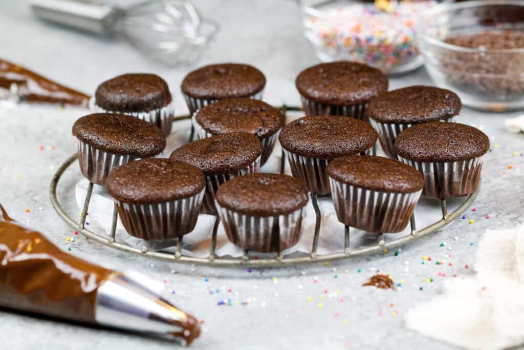 image of mini chocolate cupcakes baked and cooling on a wire rack