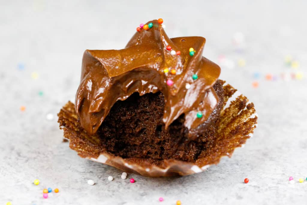 image of a mini chocolate cupcake that's been bitten into to show how moist it is