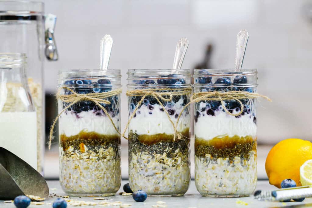 image of blueberry overnight oats filled in mason jars before being stirred with milk