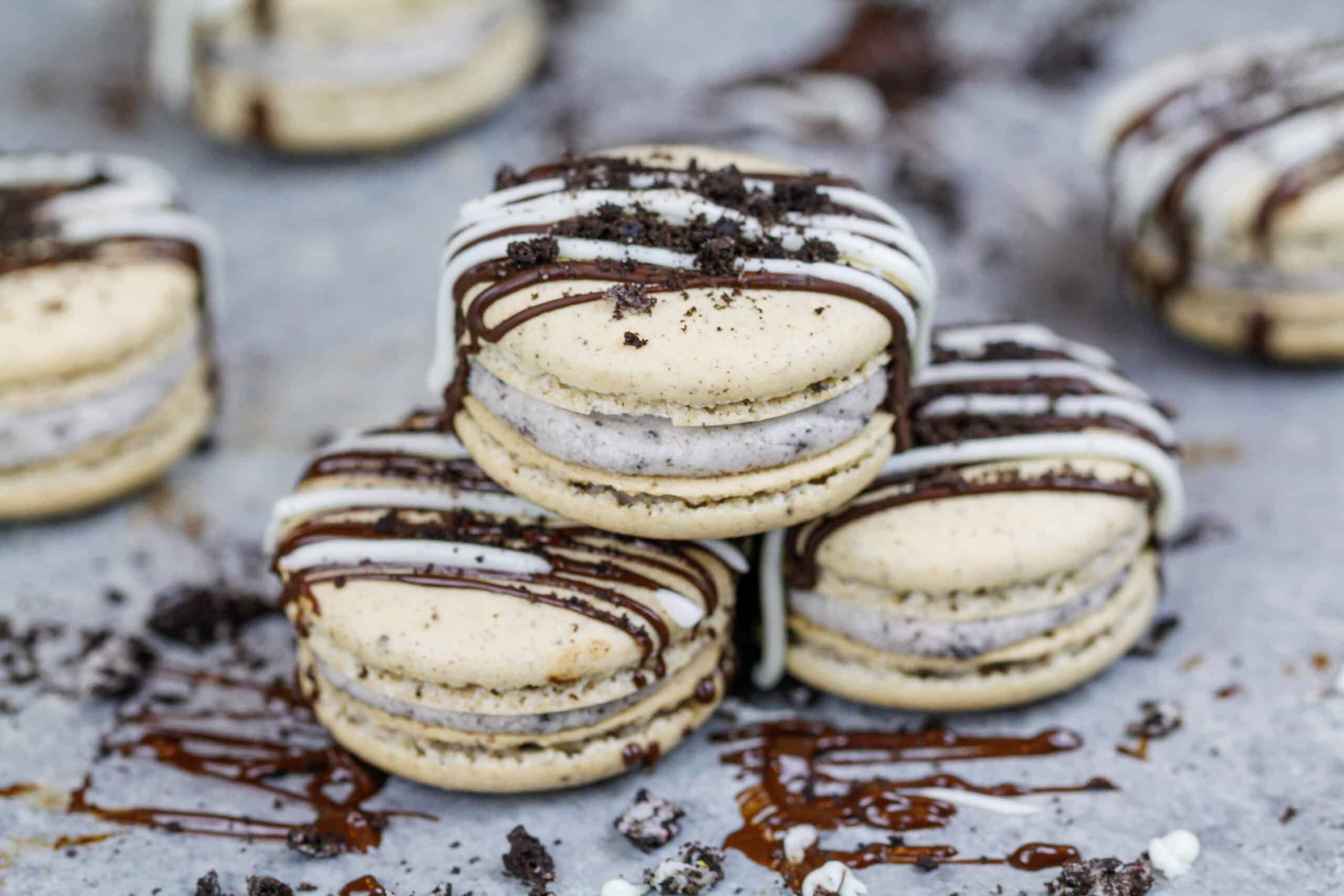 image of oreo macarons stacked on top of each other and drizzled with dark and white chocolate