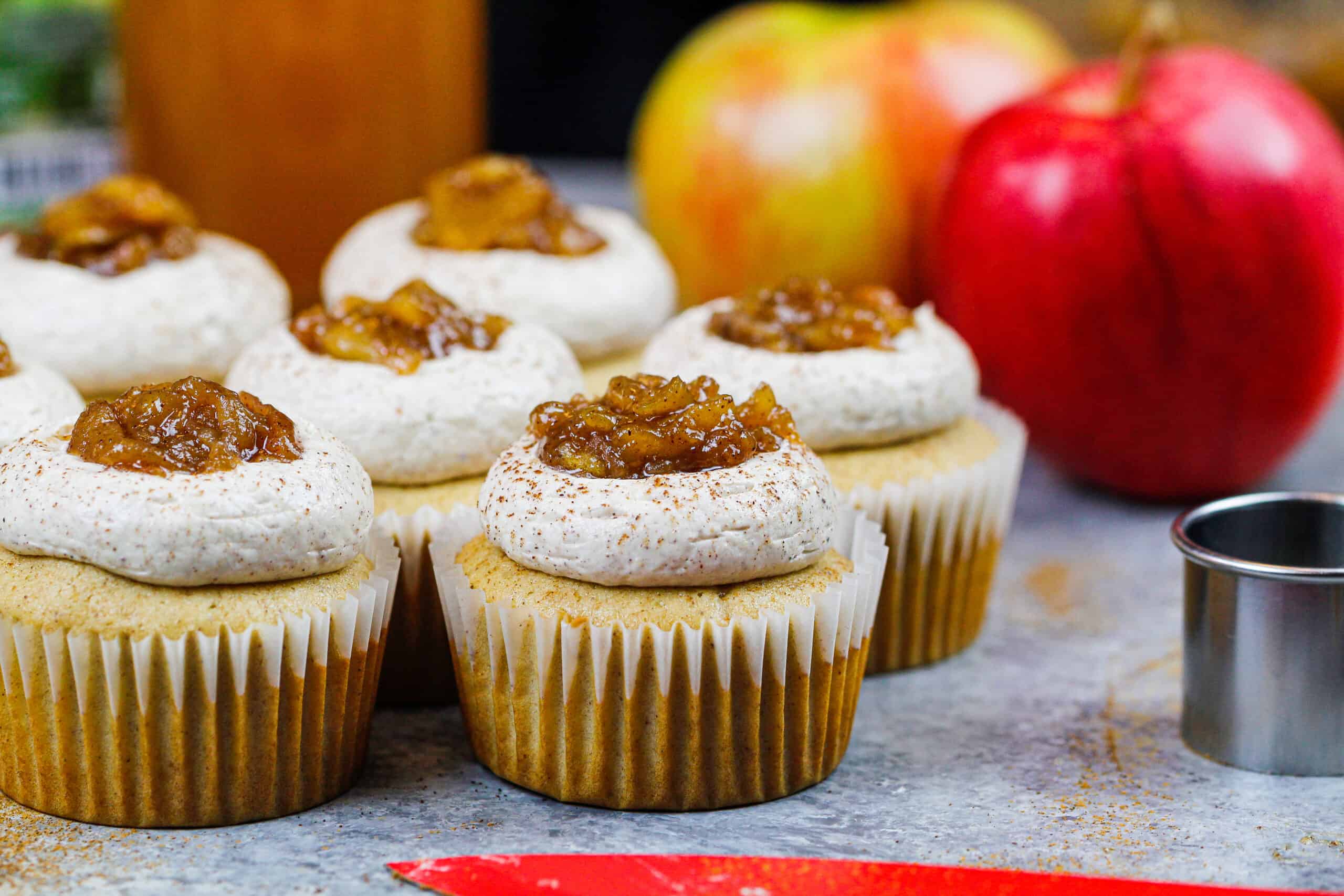 image of apple cider cupcakes topped with apple pie filling and a dusting of cinnamon