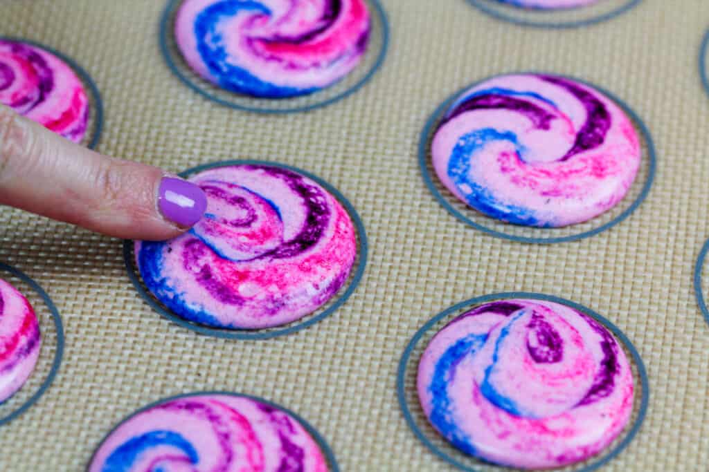 image of a cotton candy macaron shell that has rested and formed a skin and is now ready to be baked