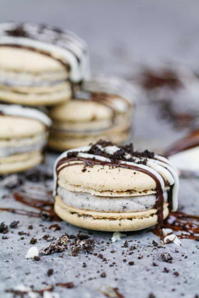 image of oreo macarons drizzled with chocolate and topped with crushed oreos