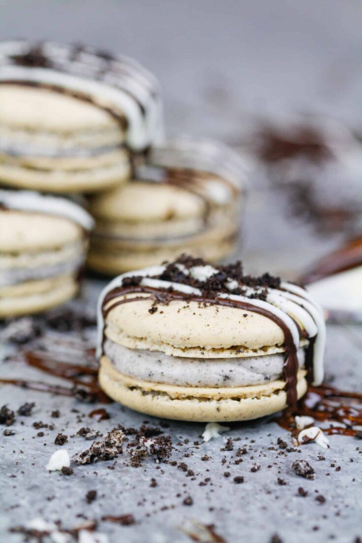 image of oreo macarons drizzled with chocolate and topped with crushed oreos