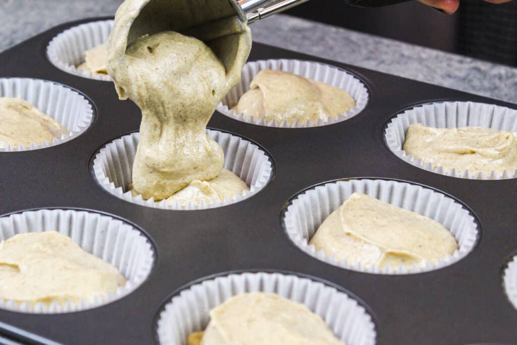 image of apple cider cupcake batter being scooped into cupcake liners to be baked
