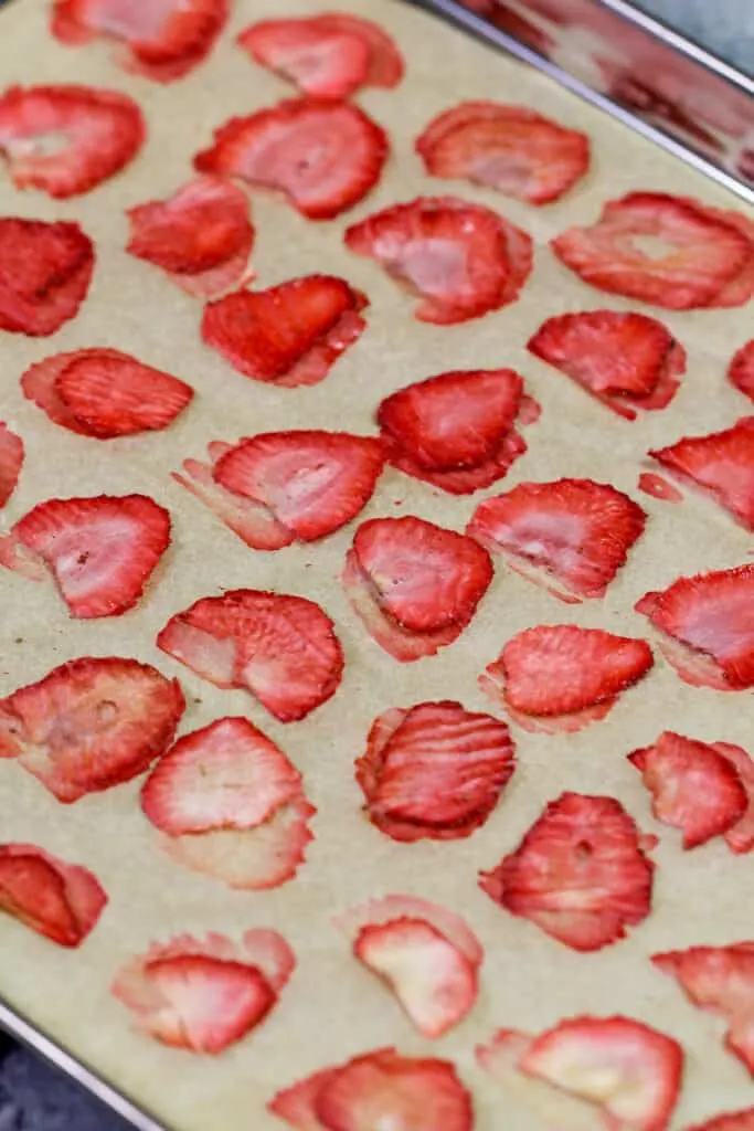 image of dried strawberries cooling on a piece of parchment paper