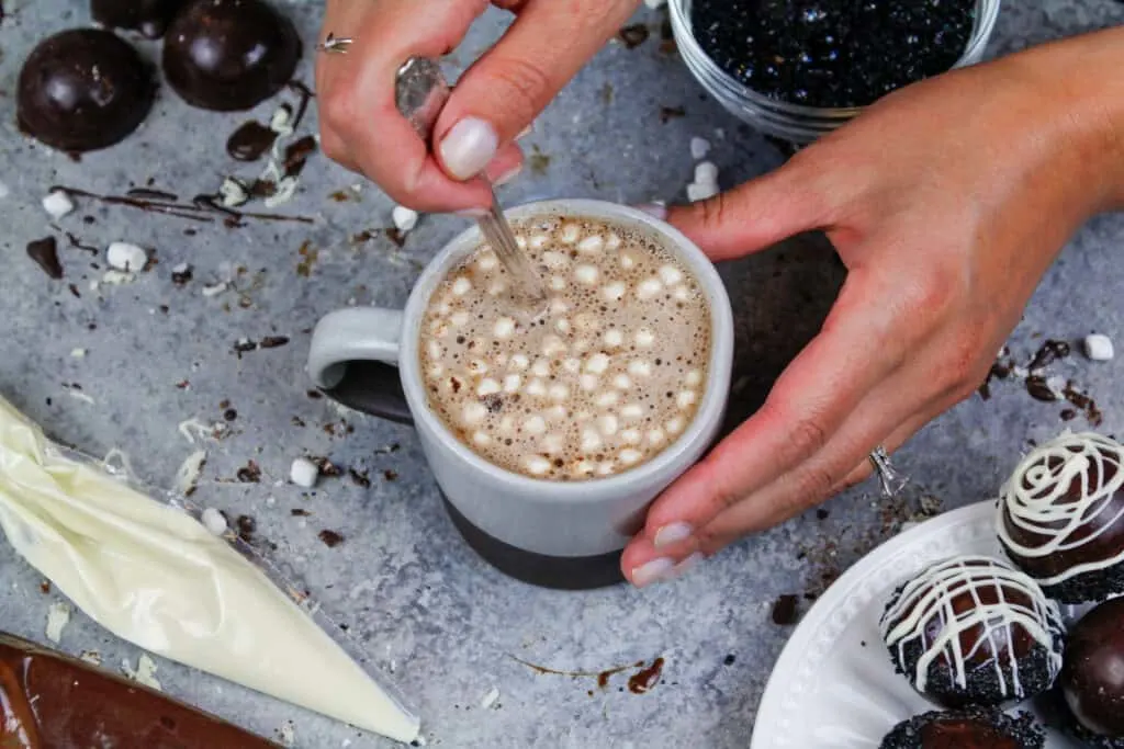 image of a mug of hot cocoa that was made with a hot chocolate bomb filled with mini marshmallows