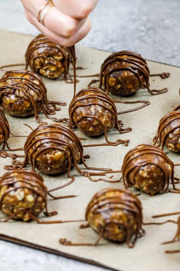 image of oatmeal peanut butter balls being drizzled with melted chocolate