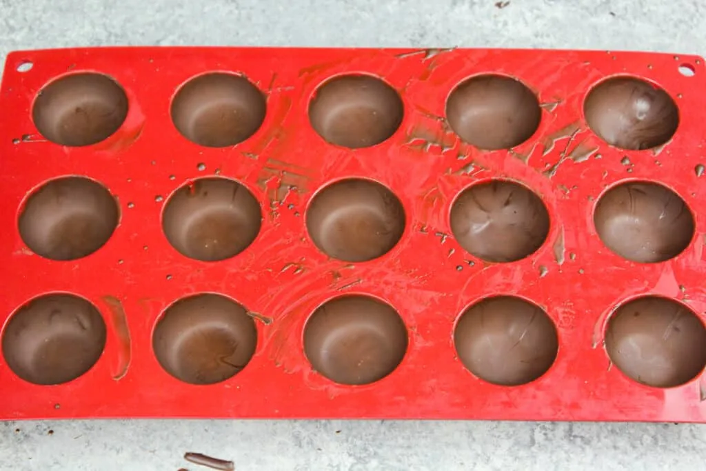 image of a small silicone mold being used to make mini hot chocolate bombs