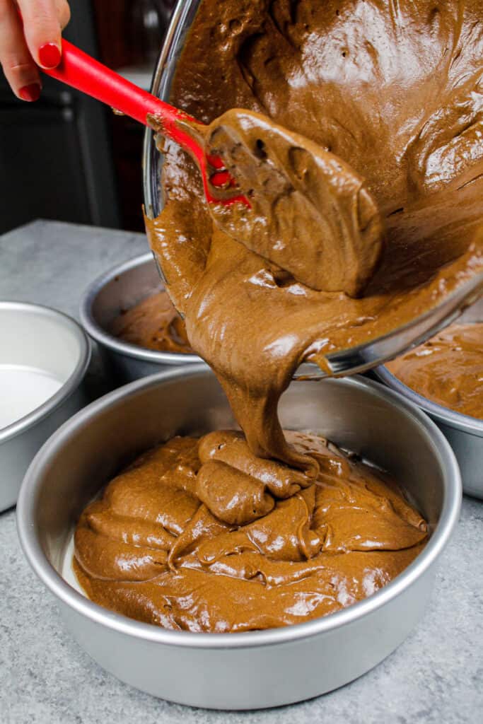 image of chocolate mocha cake batter being poured into cake pans