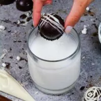 image of a hot cocoa bomb being dropped in a mug of warm milk