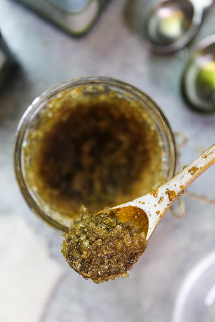 image of a vanilla brown sugar body scrub on a spoon showing its sugar granules