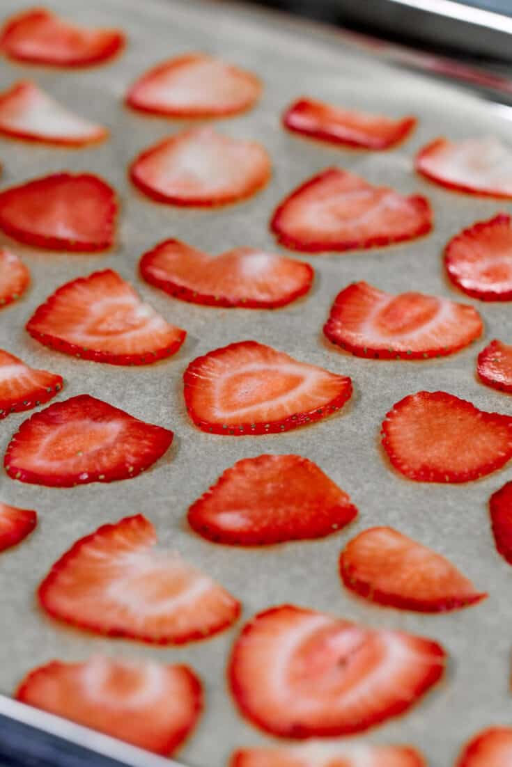 image of thinly sliced strawberries on a tray ready to be baked to become dried strawberries