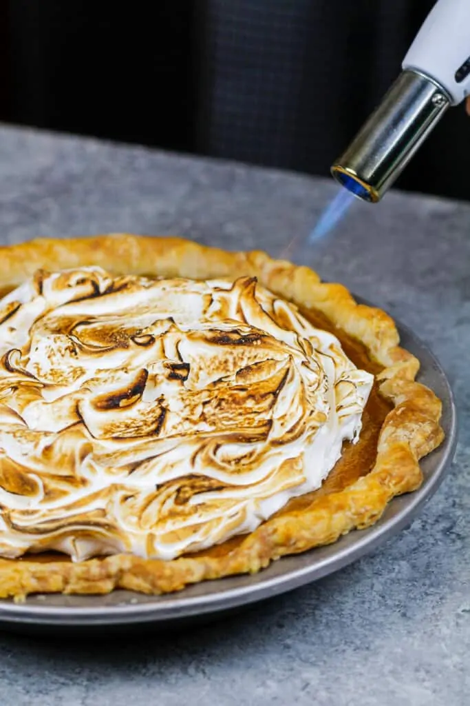 image of meringue being toasted on a mascarpone pumpkin pie