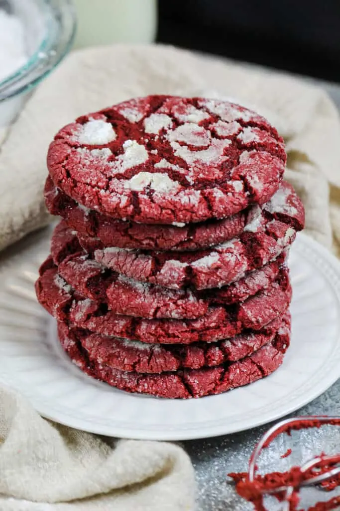 image of red velvet crinkle cookies that have been stacked on a small plate and are ready to be eaten