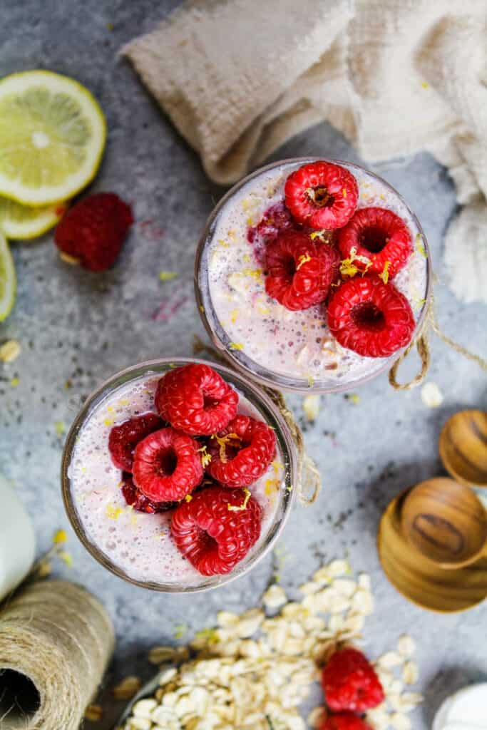 image of raspberry overnight oats that are topped with fresh raspberries and lemon zest