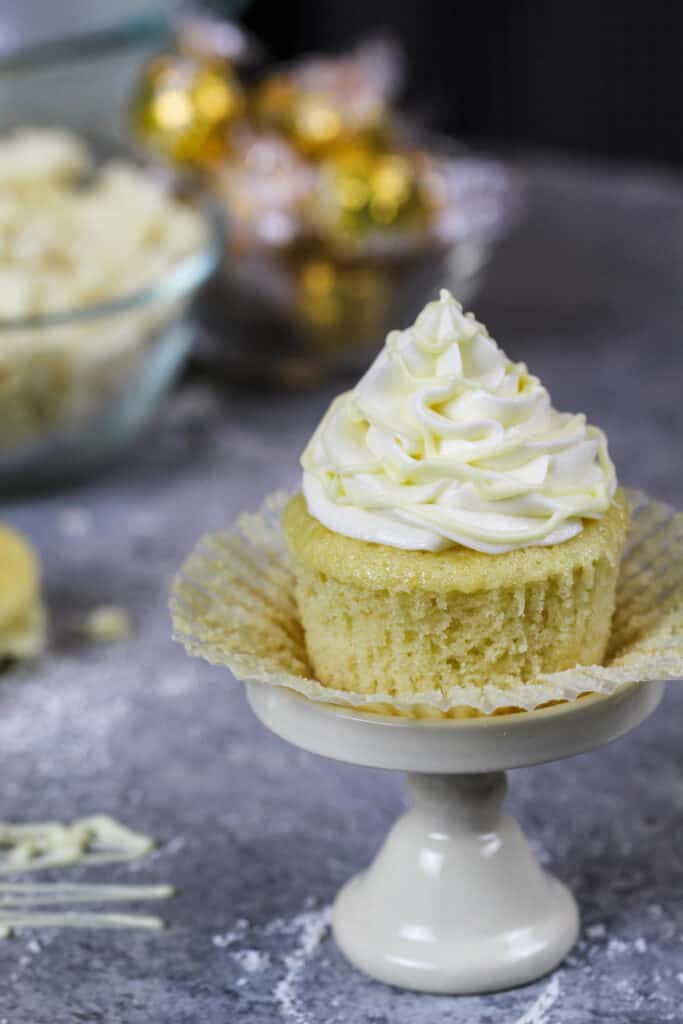 image of an unwrapped white chocolate cupcake that's been drizzled with melted white chocolate