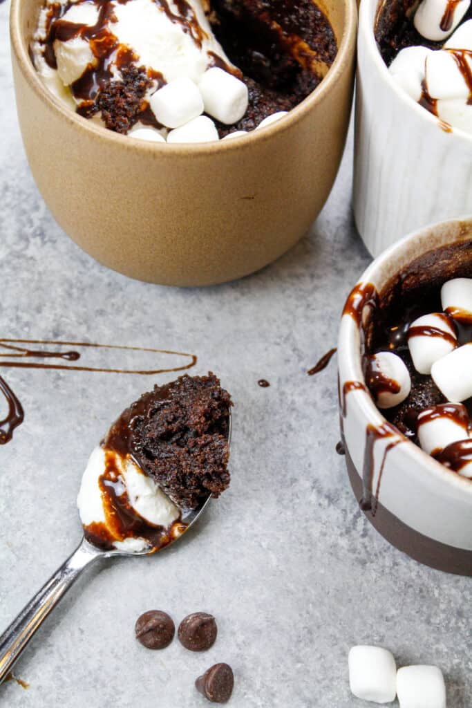image of hot cocoa mug cake with spoonful scooped out to show how moist and fluffy the cake is
