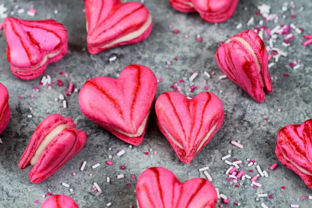 image of pink heart shaped macarons filled with buttercream