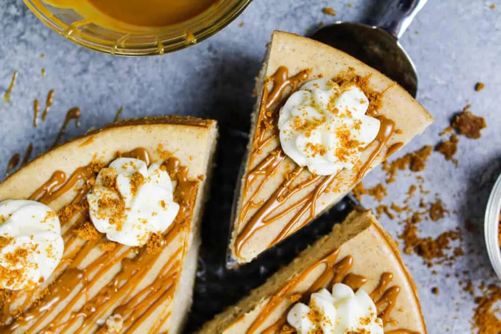 image of biscoff cheesecake that's been drizzled with warm cookie butter and topped with whipped cream