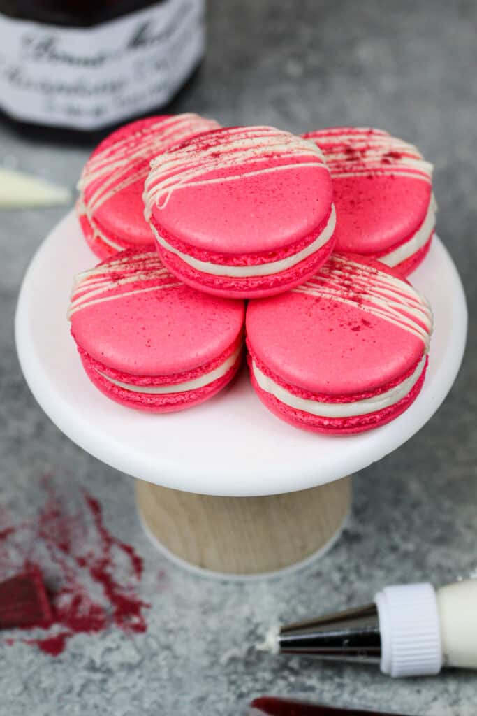 image of raspberry macarons decorated with white chocolate and freeze dried raspberry powder