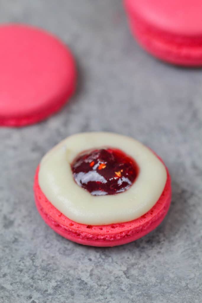 image of pink french macaron shells filled with homemade buttercream and raspberry jam