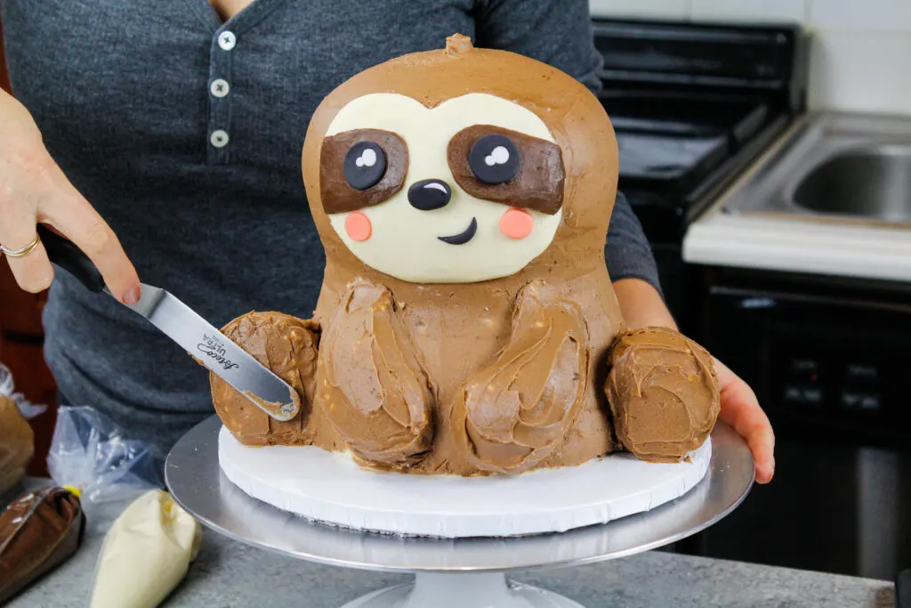 image of a sloth cake being crumb coated before its buttercream fur is piped on