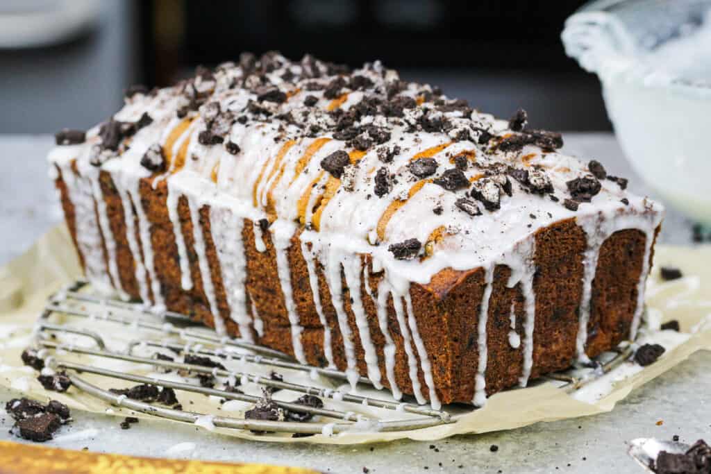 image of an oreo banana bread that's been drizzled in a cookies and cream glaze