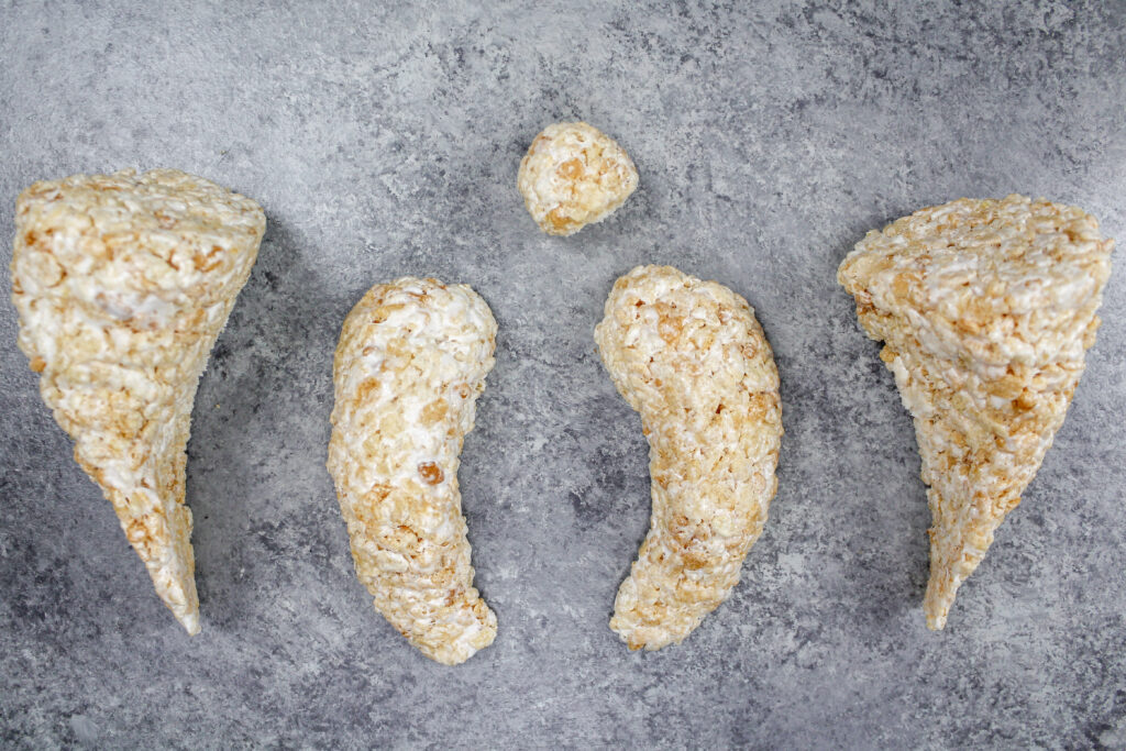 image of cake decorating rice krispies that have been shaped into arms and legs to make a polar bear cake