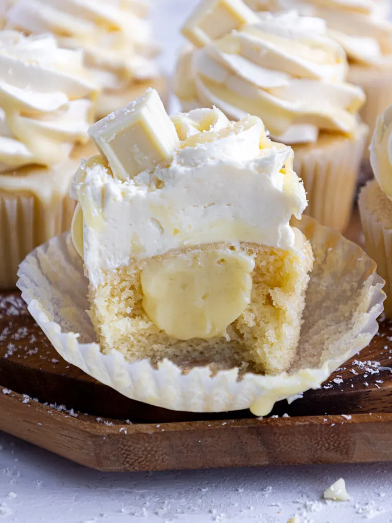 image of a white chocolate cupcake that's been cut into to show its white chocolate ganache filling