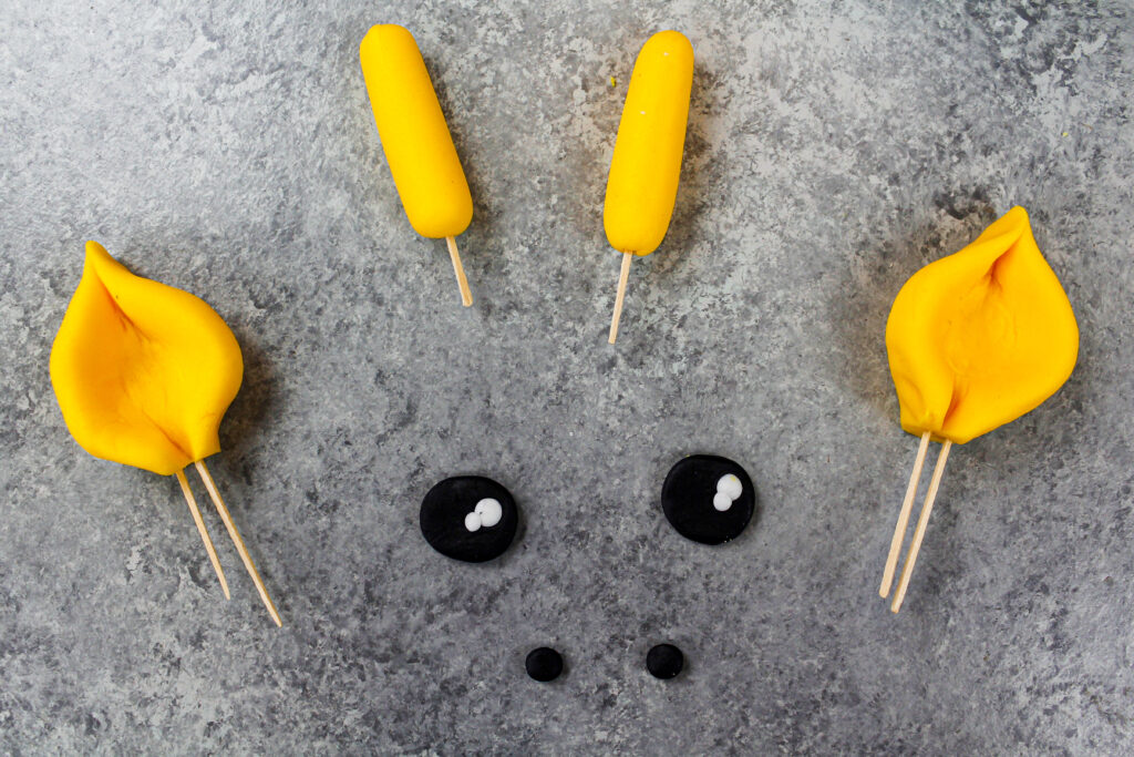 image of yellow and black fondant used to make the eyes and ears for a giraffe cake