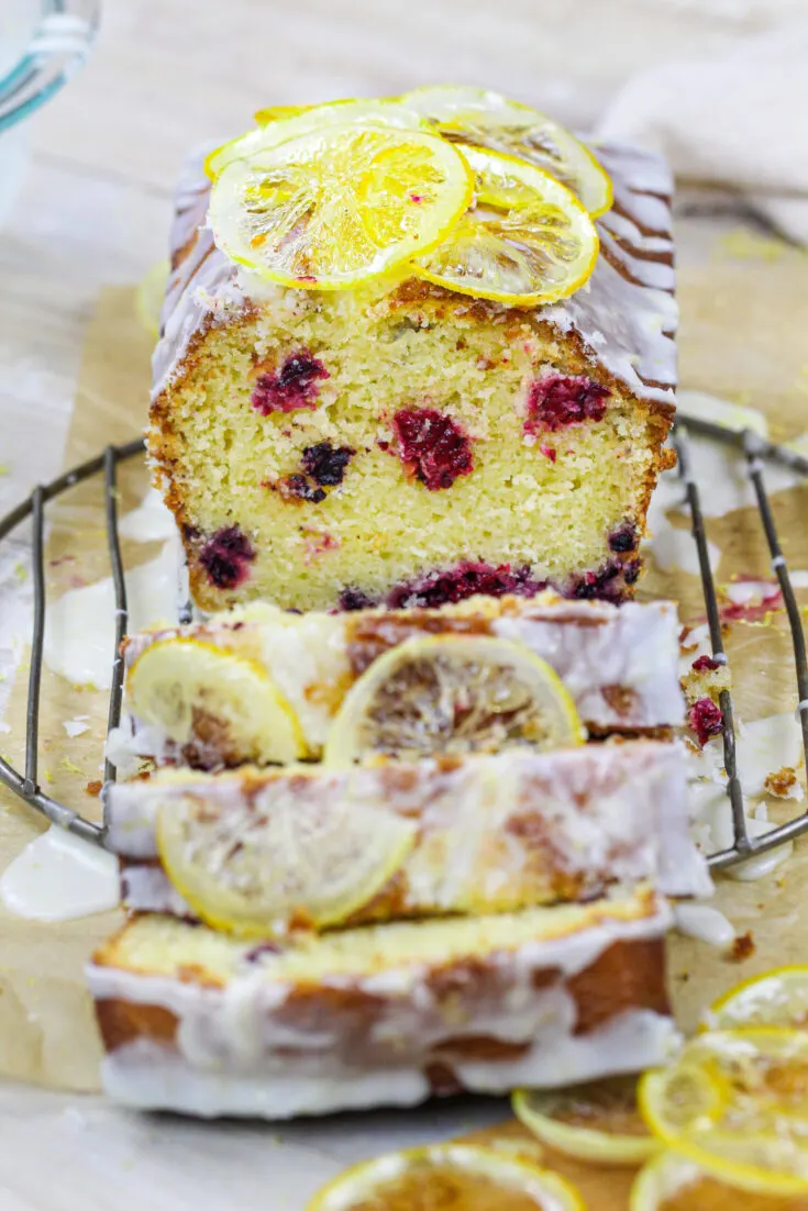 image of a blackberry lemon bread drizzled with lemon glaze and topped with candied lemons