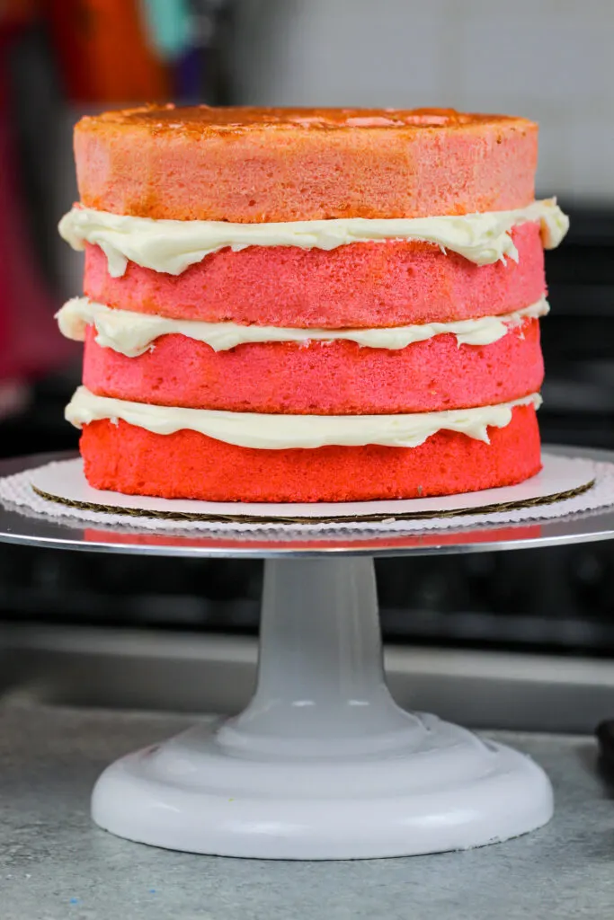 image of ombre pink cake layers stacked and frosted with american buttercream