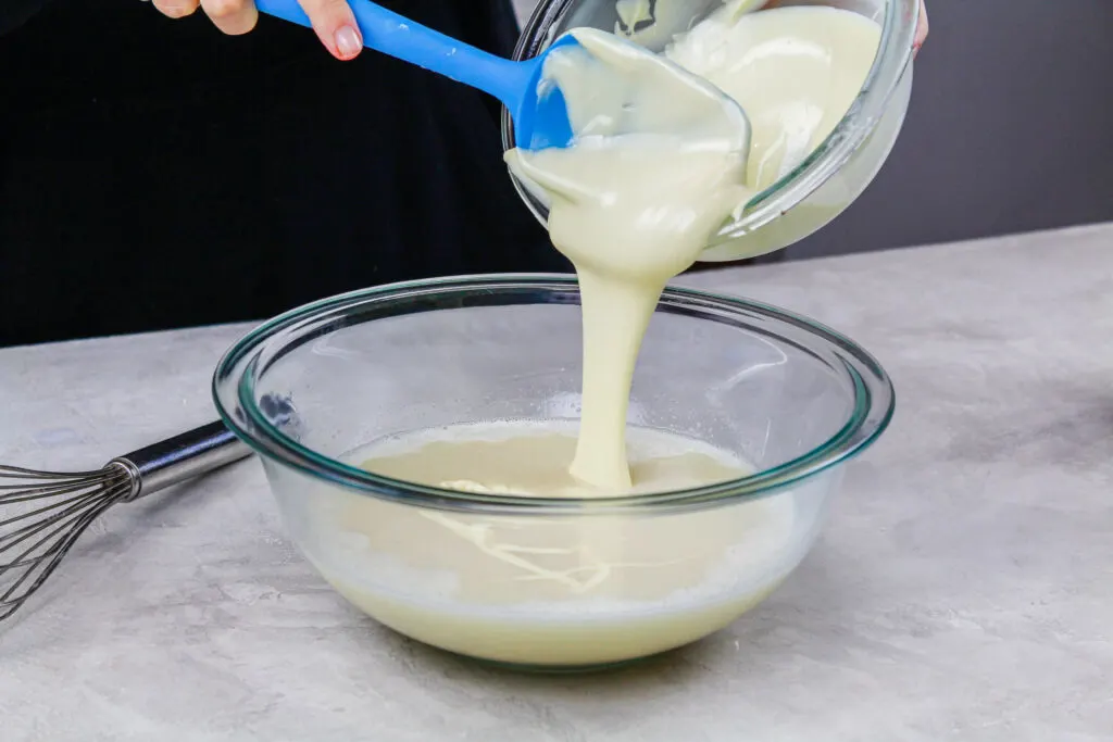 image of melted white chocolate being poured into melted gelatin to make an easy mirror glaze recipe