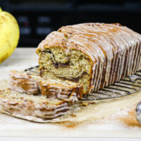 image of cinnamon swirl banana bread loaf that's been sliced into to show its beautiful cinnamon sugar swirls