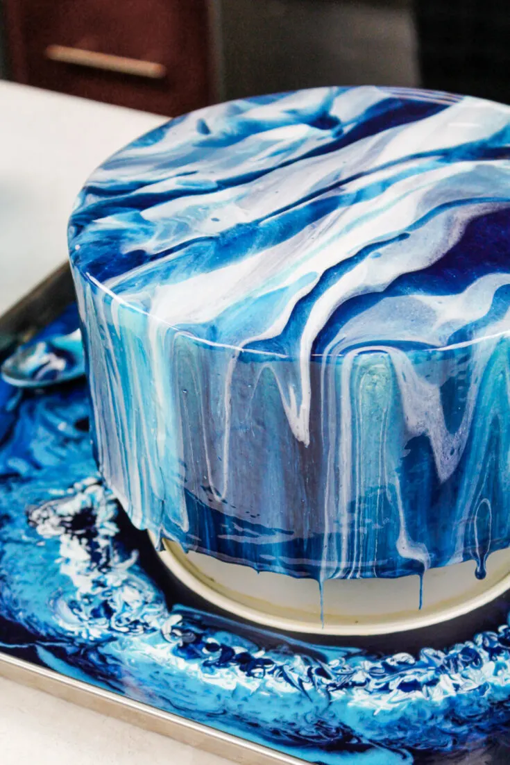 image of an ocean inspired white and blue mirror glaze cake