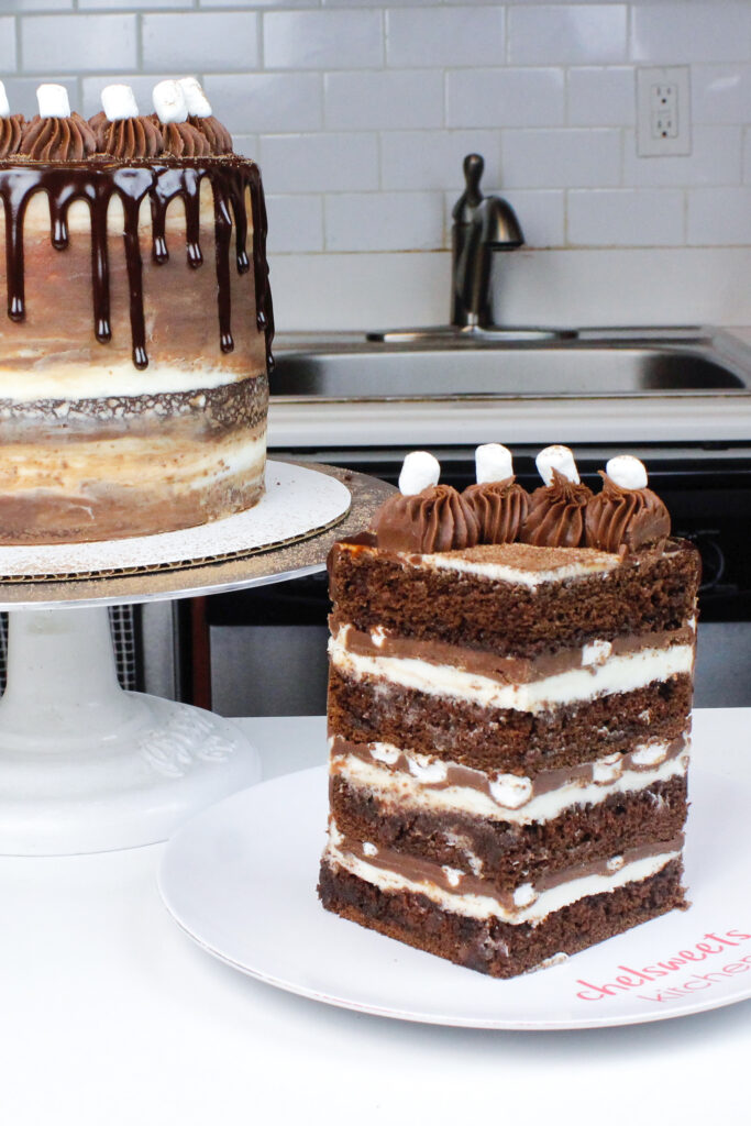 image of a hot cocoa layer cake filled with marshmallow buttercream, chocolate ganache and mini marshmallows
