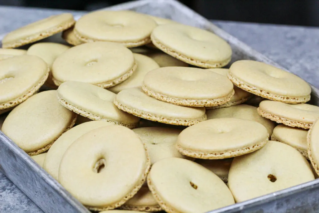 image of donut shaped macaron shells that have been baked and have perfect feet