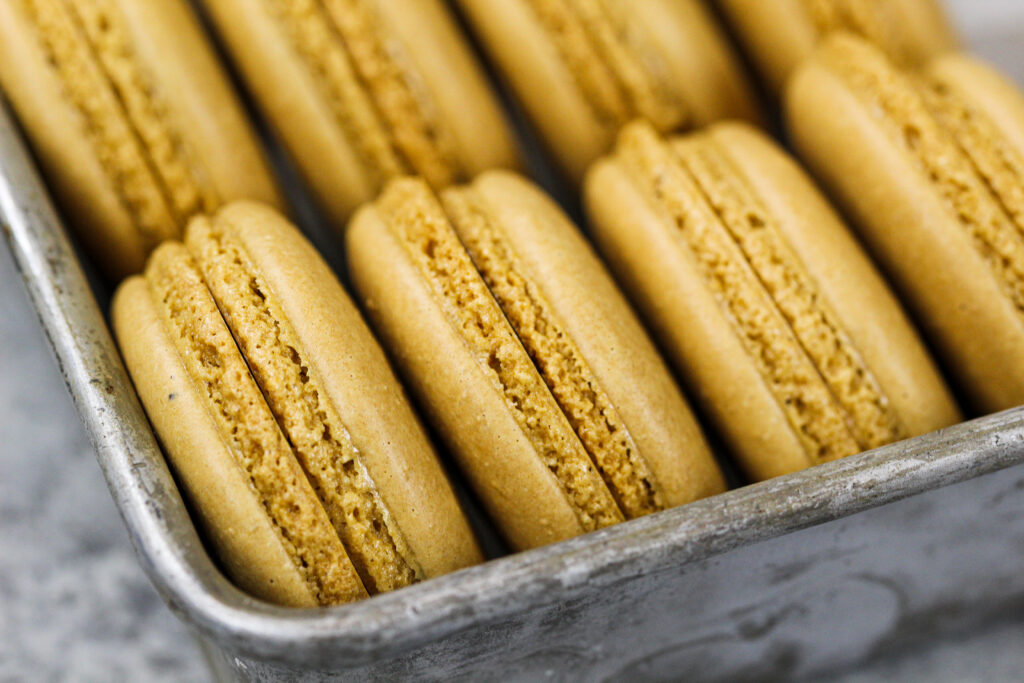 image of coffee macaron shells with perfect feed that have baked and cooled that are ready to be filled