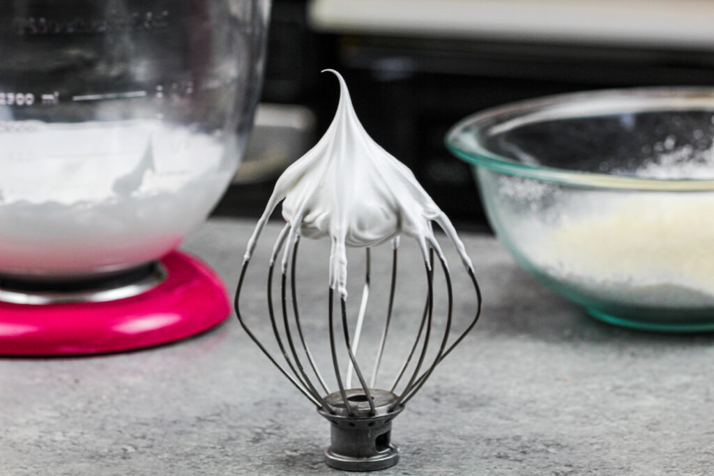 image of french meringue on a whisk of a kitchenaid mixer that has stiff peaks