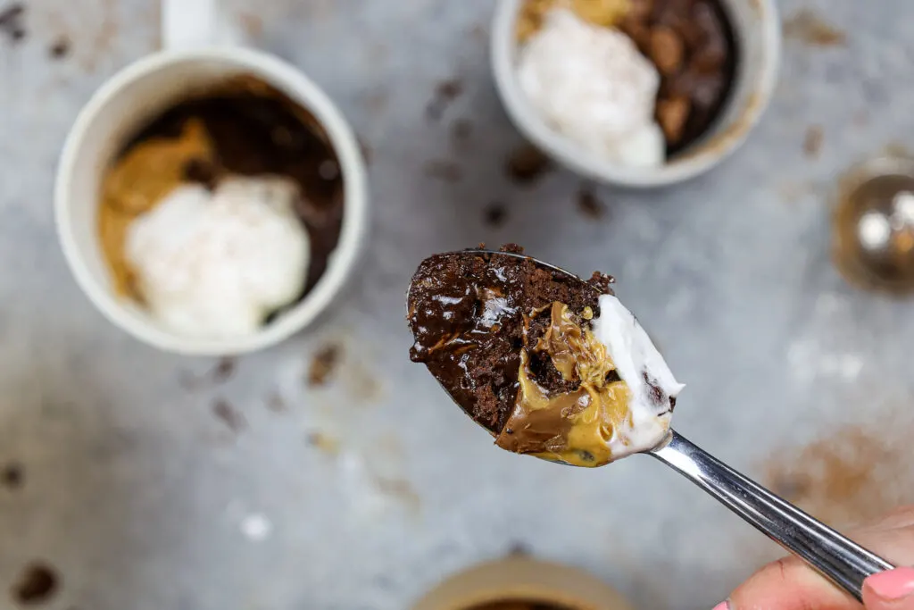 image of a bite of a gooey chocolate protein mug cake on a spoon