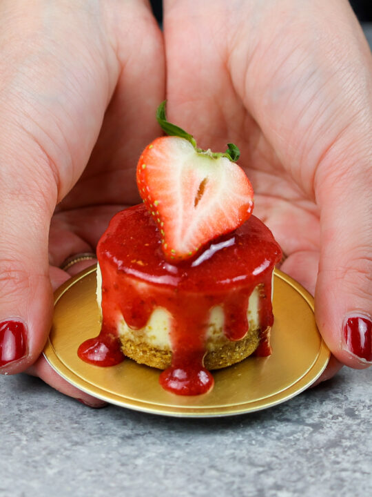 image of chelsey white of chelsweets holding a mini strawberry cheesecake in her hands
