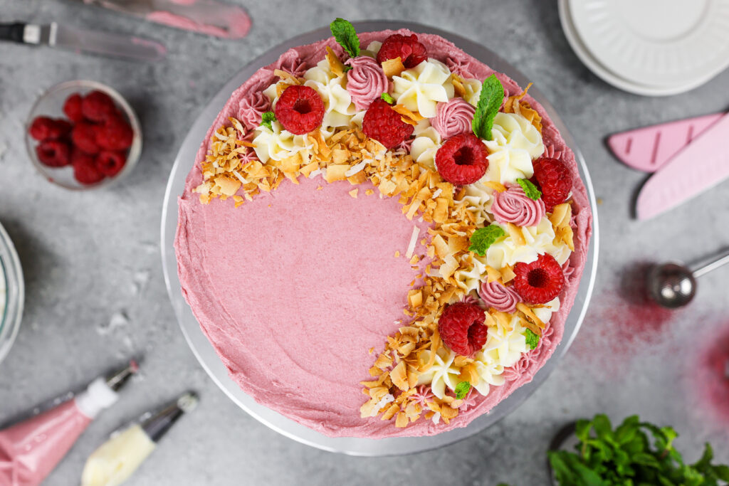 image of a raspberry coconut cake filled with raspberry jam and decorated with toasted coconut