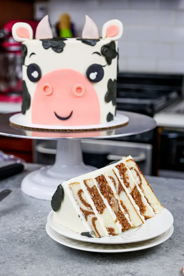 image of an adorable cow birthday cake made with marbled chocolate and vanilla cake layers