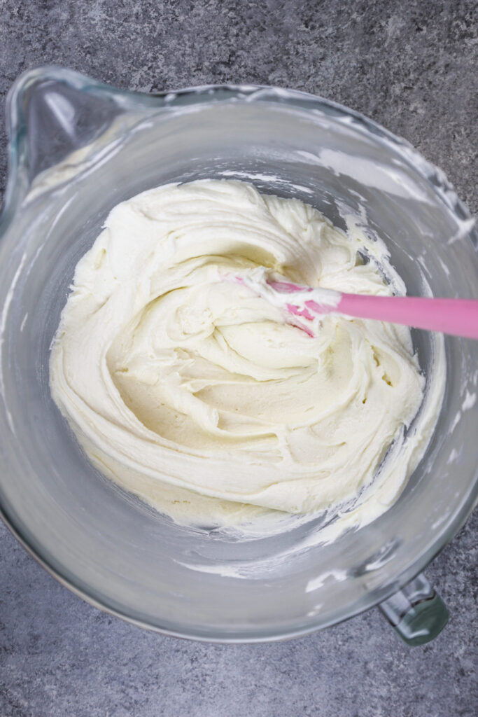 image of vanilla american buttercream in bowl that's been stirred with a spatula to make it super smooth