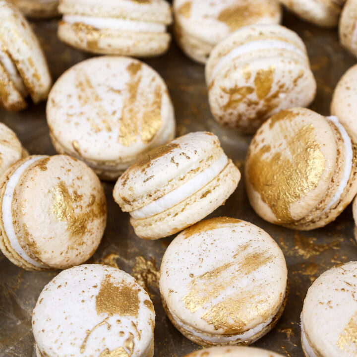 image of vanilla macarons made using the french method and decorated with edible gold paint
