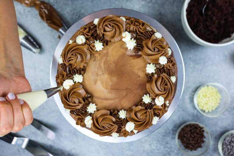 image of a triple chocolate cake slice that's filled with milk chocolate buttercream and dark chocolate ganache
