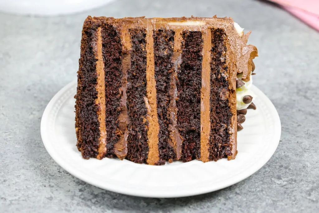 image of a triple chocolate cake slice that's filled with milk chocolate buttercream and dark chocolate ganache