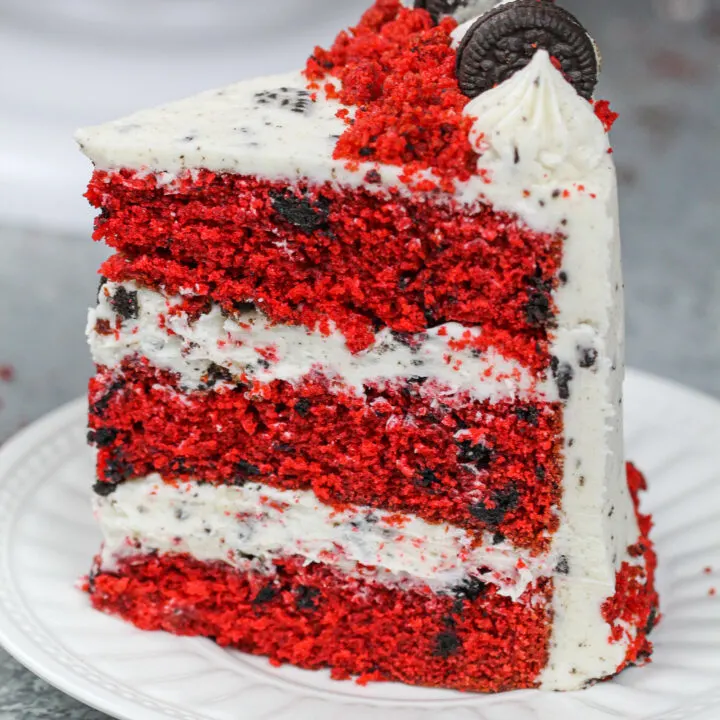 image of a slice of red velvet oreo cake that's frosted with an oreo red velvet cream cheese frosting