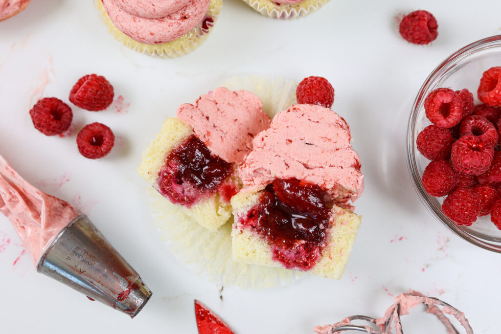 image of a raspberry cupcake that's been cut open and filled with raspberry jam